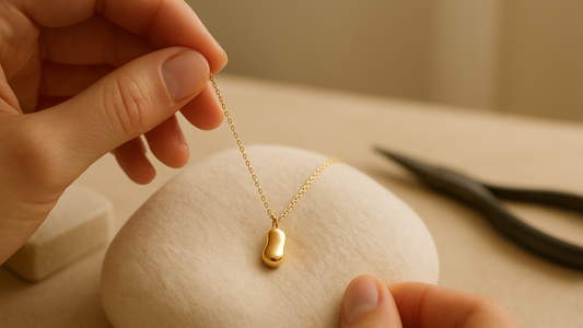 Gold bangle pair and flat-back stud earrings for an infant, shown as the safe alternative to a gold chain